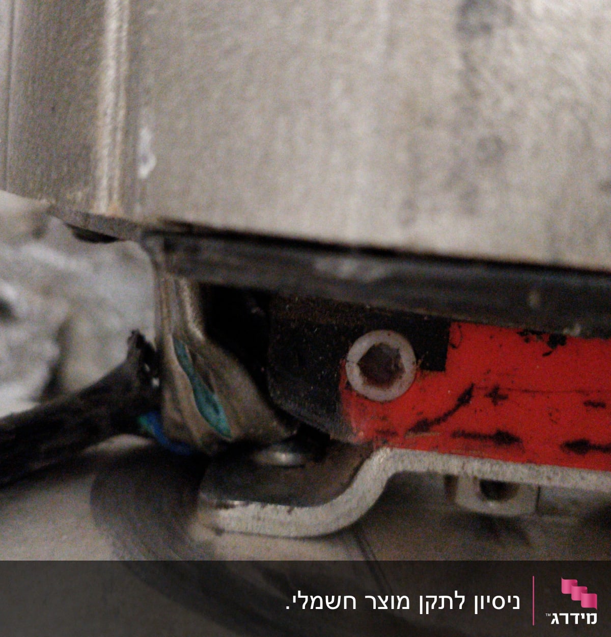 חוט חשמל מחובר למכשיר מתכת עם ברגים